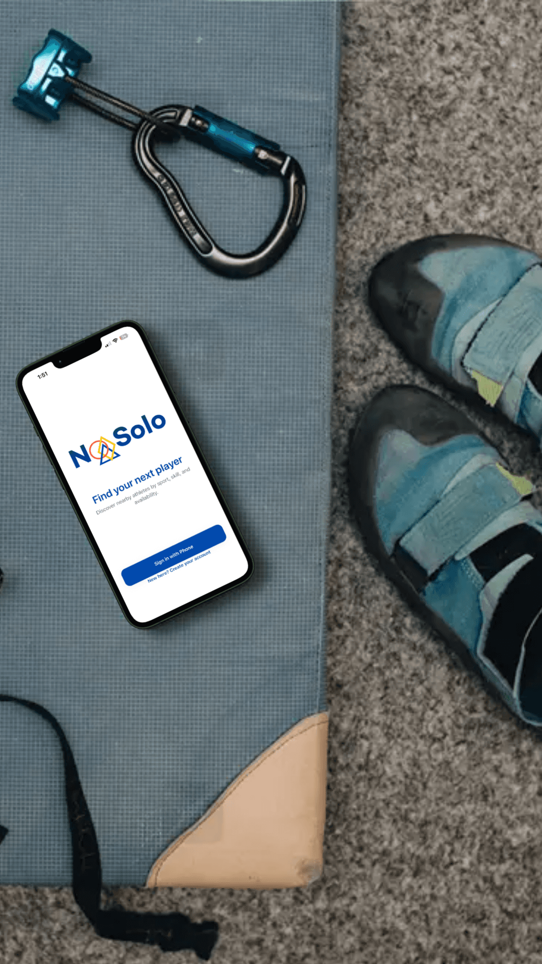 NoSolo app on a phone beside climbing shoes and climbing gear